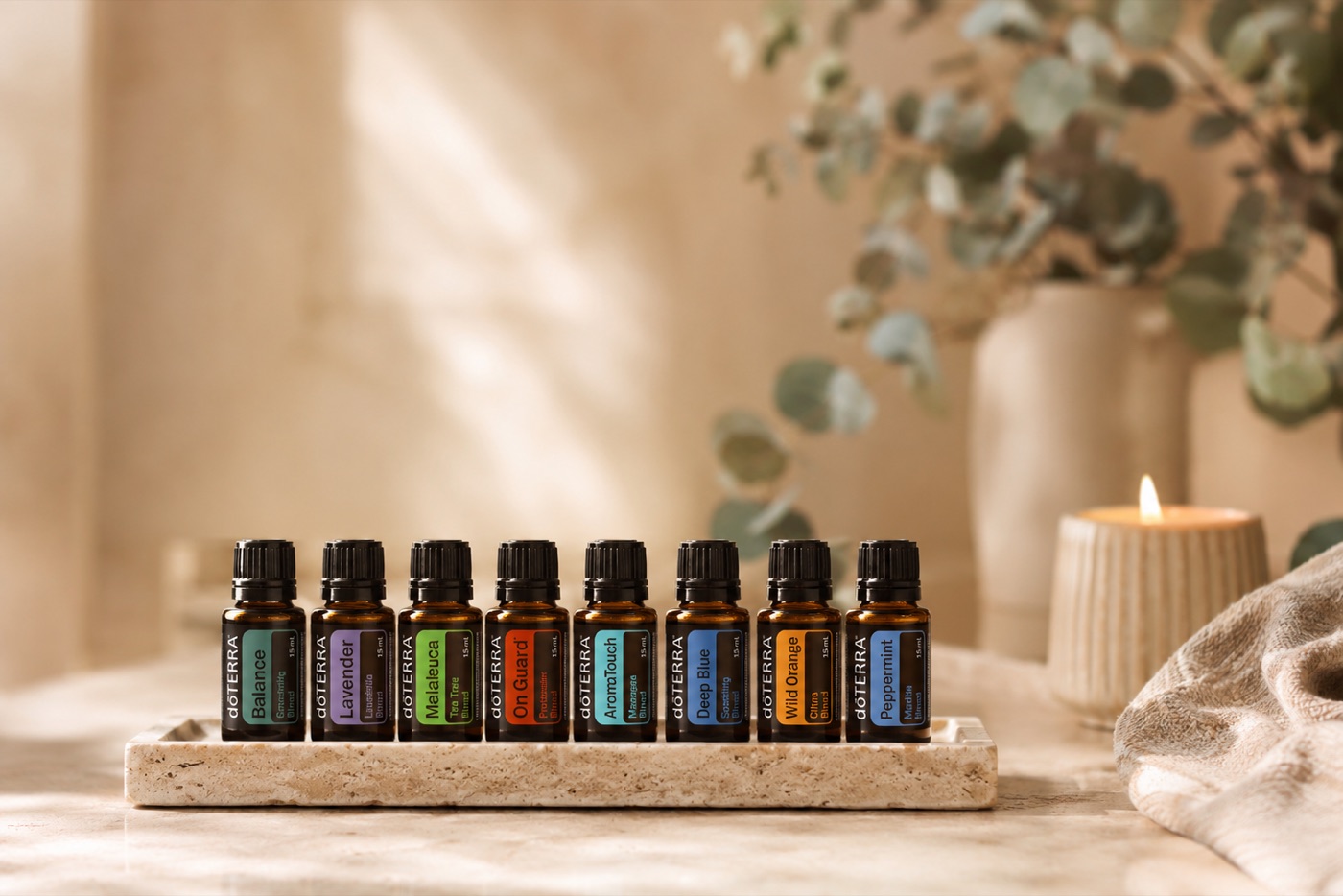 Les huit huiles essentielles dōTERRA du protocole AromaTouch alignées sur un plateau de pierre
